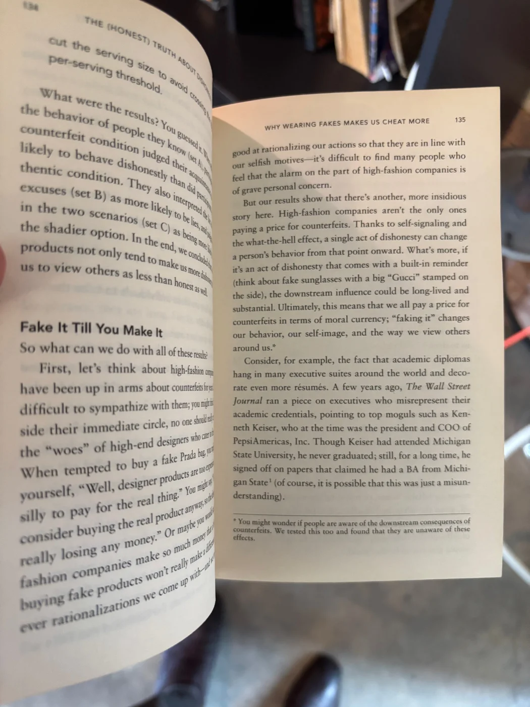 A two-page spread from The (Honest) Truth About Dishonesty by Dan Ariely, on the chapter Why Wearing Fakes Makes Us Cheat More