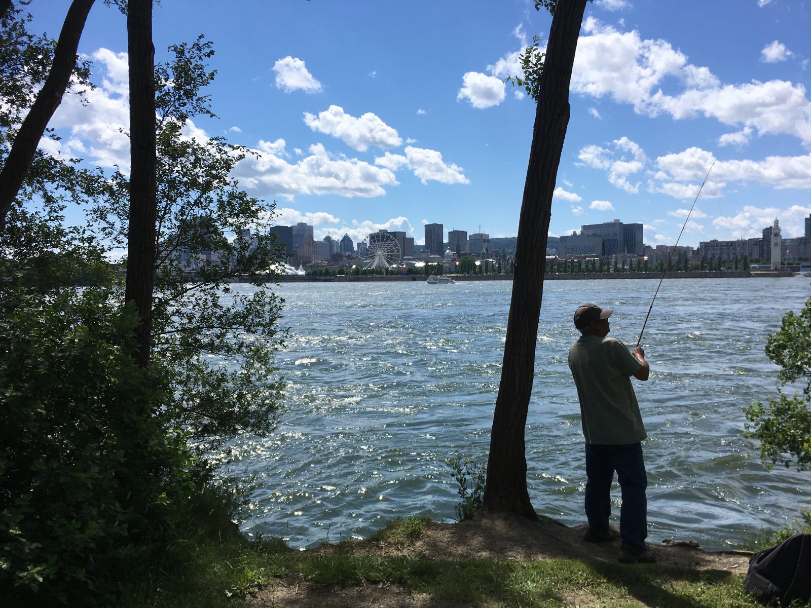 A fisherman on the banks of the St Lawrence across from Old Montreal