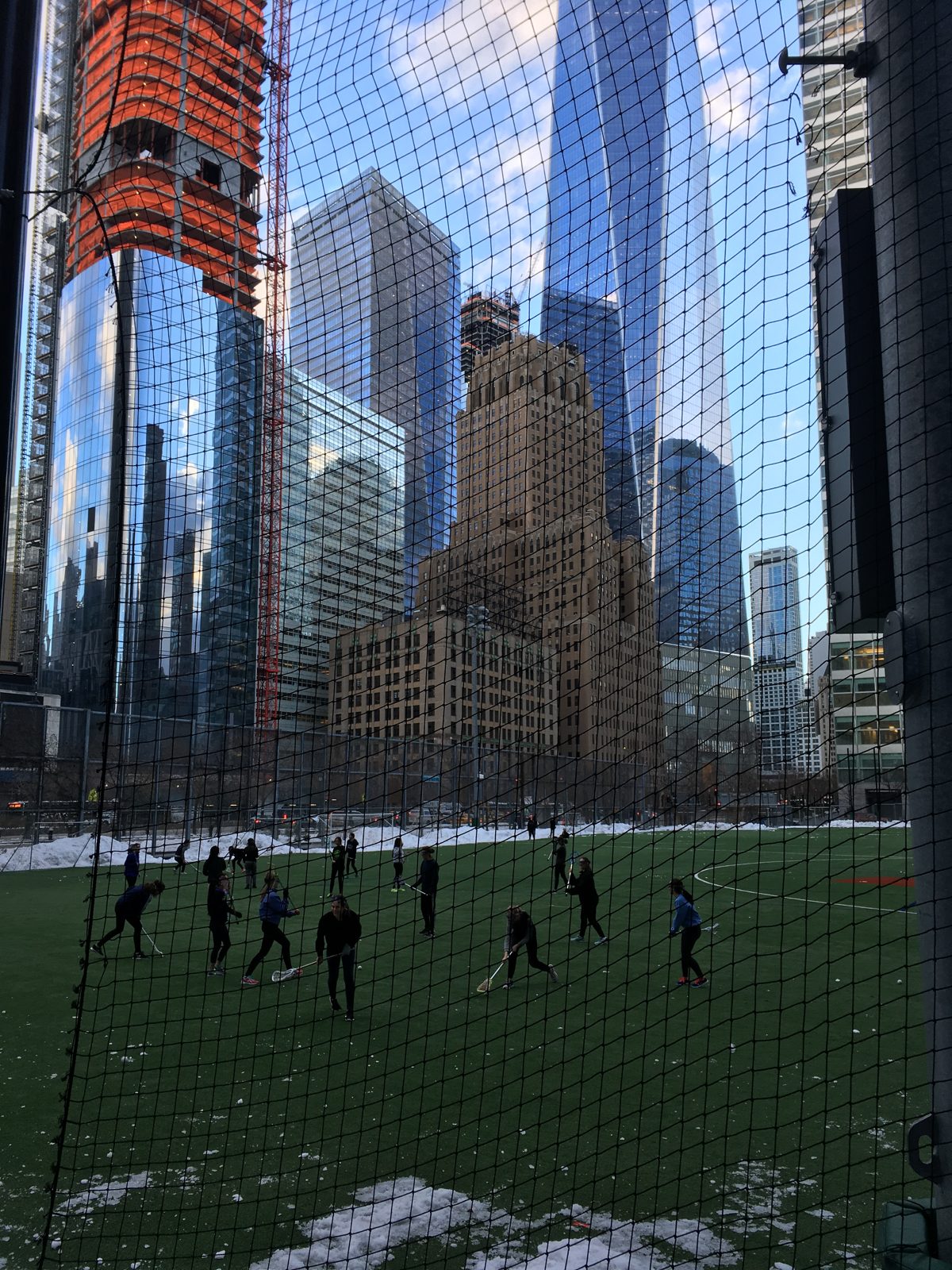 Girls practise lacrosse on an artificial field in lower manhattan